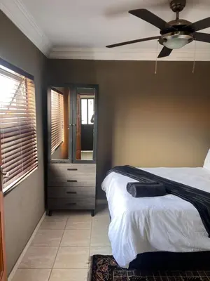 a bedroom with a bed and a ceiling fan at MorningMist Boutique 27 Room 5 in Centurion
