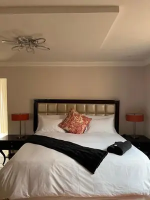 a bedroom with a large white bed with two lamps at Morningmist Boutique 27 Room 3 in Centurion