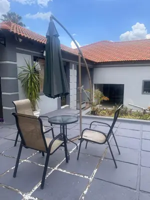 a table and two chairs and an umbrella on a patio at Morningmist Boutique 27 Room 3 in Centurion