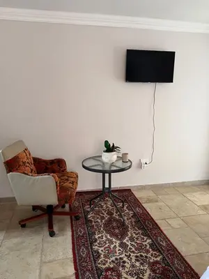 a room with a chair and a table and a television at Morningmist Boutique 27 Room 3 in Centurion