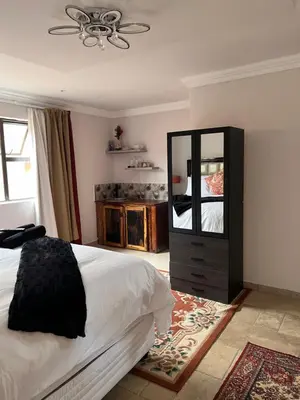 a bedroom with a bed and a dresser and a mirror at Morningmist Boutique 27 Room 3 in Centurion