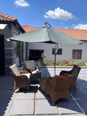 a group of chairs and an umbrella on a patio at MorningMist Boutique 27 Room 2 in Centurion