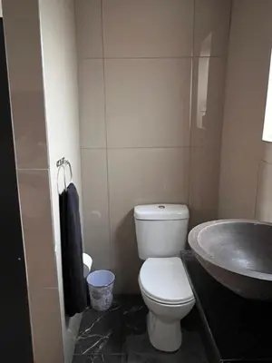 a bathroom with a white toilet and a sink at MorningMist Boutique 27 Room 2 in Centurion