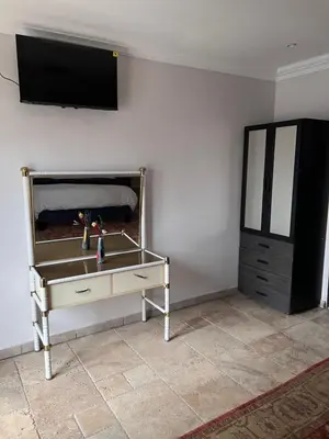 a dresser with a flat screen tv on a wall at MorningMist Boutique 27 Room 2 in Centurion