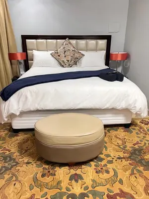 a bedroom with a large bed with a large ottoman at MorningMist Boutique 27 Room 4 in Centurion