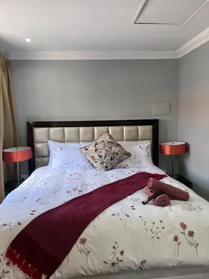 a bedroom with a large bed with two lamps at MorningMist Boutique 27 Room 4 in Centurion