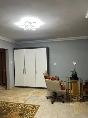 a living room with a chair and a glass table at MorningMist Boutique 27 Room 4 in Centurion