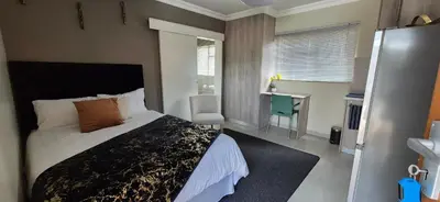 a bedroom with a bed and a desk in it at Ekuhlaleni Room 6 in Pretoria