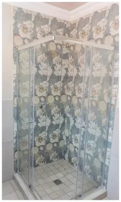 a shower in a bathroom with a floral wallpaper at Ekuhlaleni Room 6 in Pretoria