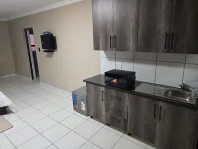 a kitchen with a sink and a microwave at La Majestic Guest Lodge in Centurion