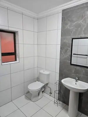 a white bathroom with a toilet and a sink at La Majestic Guest Lodge in Centurion
