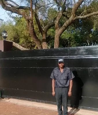 a man standing in front of a black wall at La Majestic Guest Lodge in Centurion