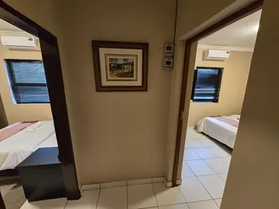 a room with two beds and a hallway with a mirror at La Majestic Guest Lodge in Centurion