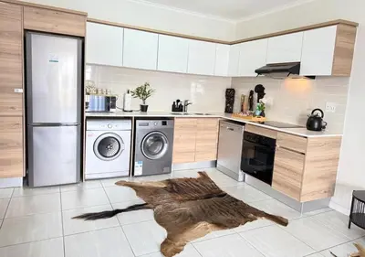 a kitchen with a washer and dryer on the floor at Zuri Marula Luxe in Midrand