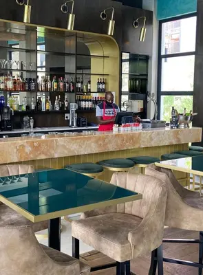 a man standing at a bar in a restaurant at Zuri Marula Luxe in Midrand