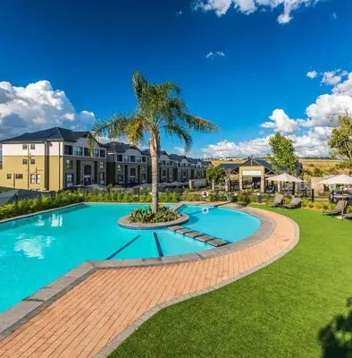 a pool with a palm tree in front of a building at Zuri Marula Luxe in Midrand