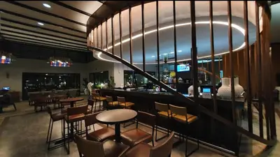 a restaurant with a bar with chairs and tables at Zuri Marula Luxe in Midrand