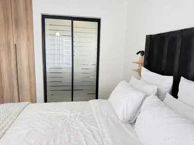 a bedroom with a white bed with white sheets and pillows at Zuri Marula Luxe in Midrand