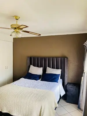 a bedroom with a bed with blue pillows and a ceiling at 2 Heron street,stonenge vidago 6 in Nelspruit