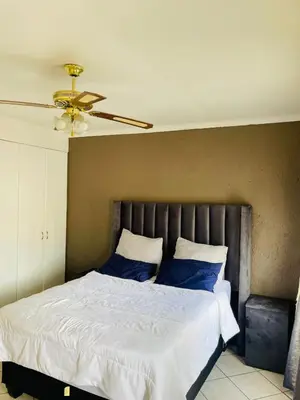 a bedroom with a large bed with blue pillows at 2 Heron street,stonenge vidago 6 in Nelspruit