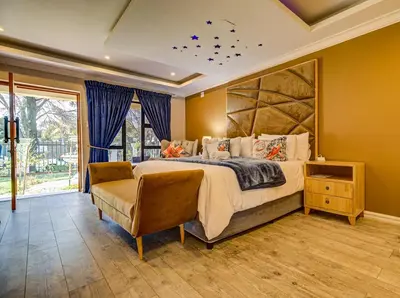 a bedroom with a large bed and a large window at Eagle Rock Executive Guest House in Kempton Park