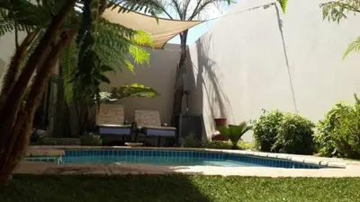 a swimming pool in a yard next to a building at Eagle Rock Executive Guest House in Kempton Park