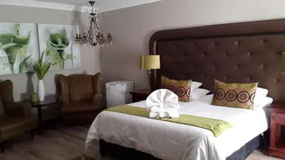 a hotel room with a bed with a hat on it at Eagle Rock Executive Guest House in Kempton Park