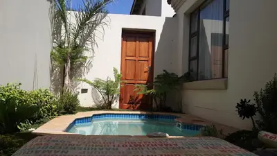 a house with a swimming pool in front of a door at Eagle Rock Executive Guest House in Kempton Park