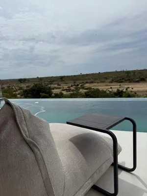 a chair and a table on a balcony with the water at Shira Lodge Africa