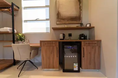 a room with a desk with a refrigerator and a chair at Shira Lodge Africa