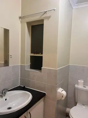 a bathroom with a sink and a toilet and a mirror at Menlyn Place 512 in Pretoria