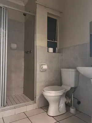 a bathroom with a toilet and a shower and a sink at Menlyn Place 512 in Pretoria