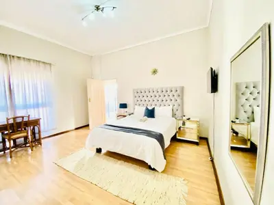 a bedroom with a large bed and a mirror at Siena Sun Celebration House Party friendly noise tolerant in Midrand
