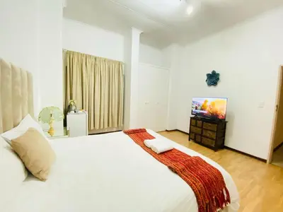 a bedroom with a white bed and a tv at Siena Sun Celebration House Party friendly noise tolerant in Midrand
