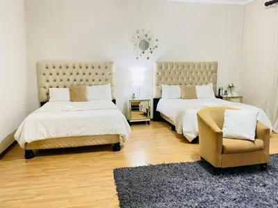 a bedroom with two beds and a chair and a rug at Siena Sun Celebration House Party friendly noise tolerant in Midrand
