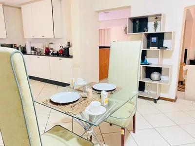 a dining table and chairs in a living room at Siena Sun Celebration House Party friendly noise tolerant in Midrand
