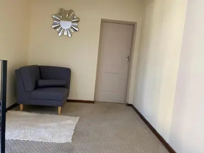 a room with a blue chair and a clock on the wall at Siena Sun Celebration House Party friendly noise tolerant in Midrand