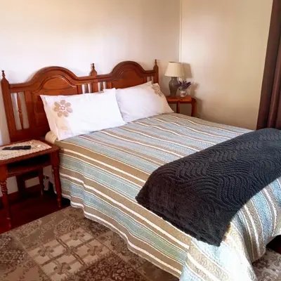 a bedroom with a bed and a table with a lamp at 6 on First Self catering in Pretoria