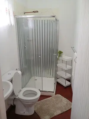 a bathroom with a shower and a toilet and a sink at 6 on First Self catering in Pretoria