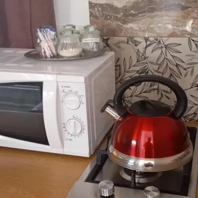 a red tea kettle sitting on top of a microwave at 6 on First Self catering in Pretoria