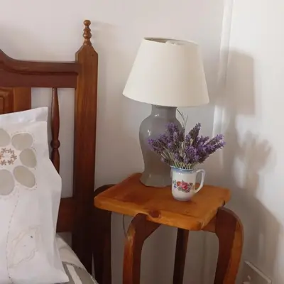 a table with a lamp and a cup of flowers on it at 6 on First Self catering in Pretoria