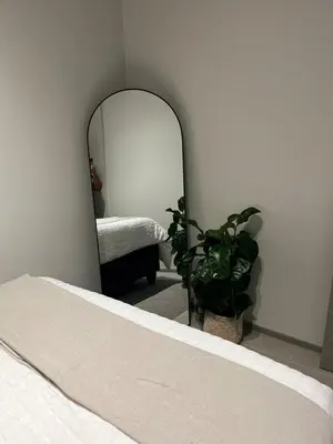 a bedroom with a bed and a mirror at The Aura at Castle Gate in Pretoria