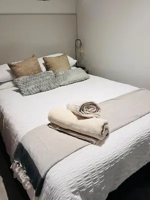 a large white bed with pillows and blankets on it at The Aura at Castle Gate in Pretoria