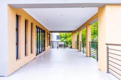 an empty hallway of a building with yellow walls and windows at Tindlovu GuestT House in Nelspruit