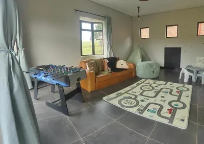 a living room with a couch and a table with a chessboard at Shalom Mountain & Fly-Fishing Lodge in Dullstroom