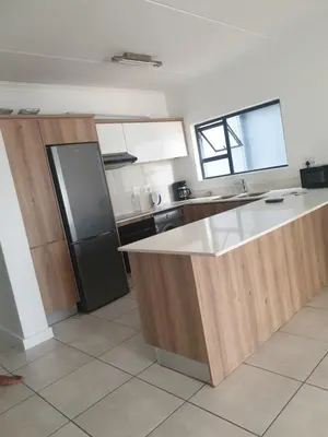 a kitchen with a white counter and a black refrigerator at The Blyde resort in Pretoria