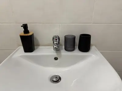 a bathroom sink with two cups on top of it at The Minimalist Suite in Kempton Park