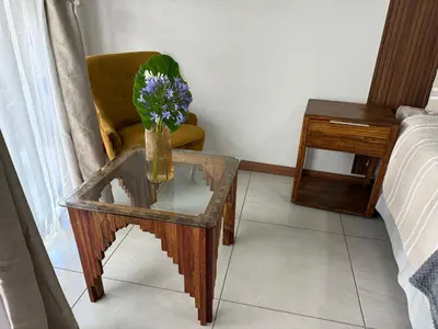 a vase of flowers on a table in a room at The Minimalist Suite in Kempton Park