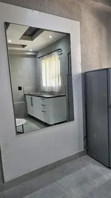 a mirror in a room with a counter and a kitchen at Questro Apartment Hotel in eNyamazaneni