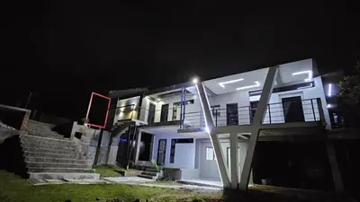 a white house at night with lights on it at Questro Apartment Hotel in eNyamazaneni